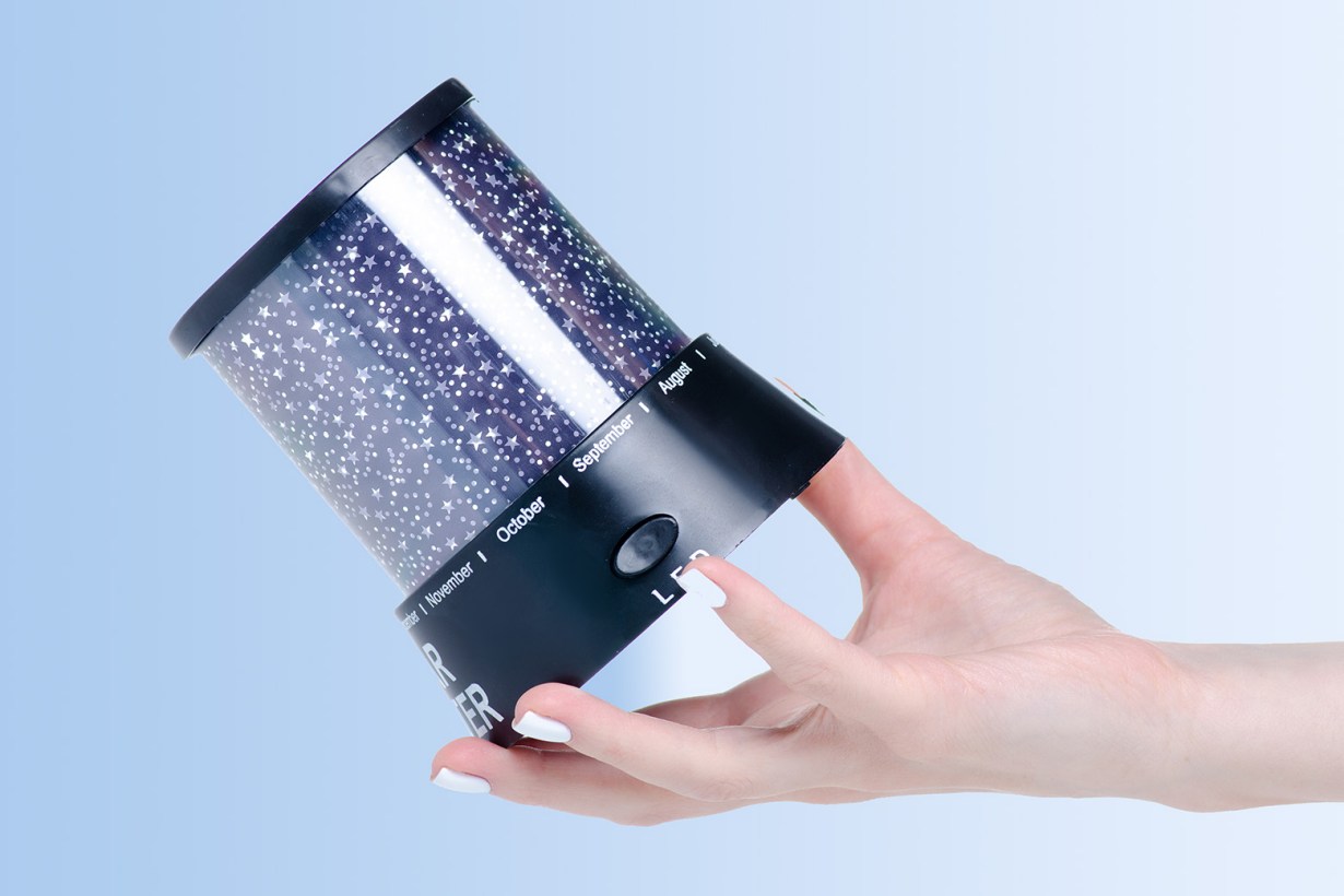 a hand holding a galaxy projector