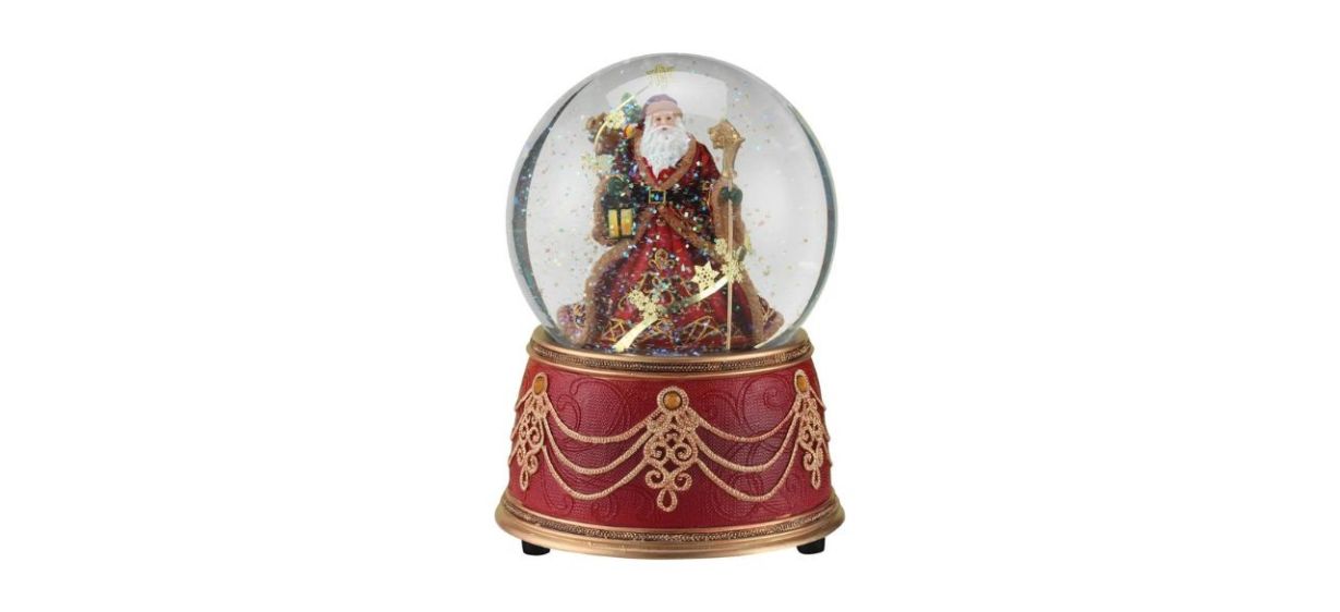 a snowglobe with a red base and a globe with Santa in it holding a lantern and staff a snowglobe with a red base and a globe with Santa in it holding a lantern and staff