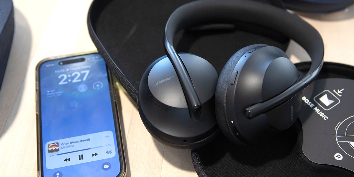 Bose QuietComfort Ultra Headphones in case next to phone