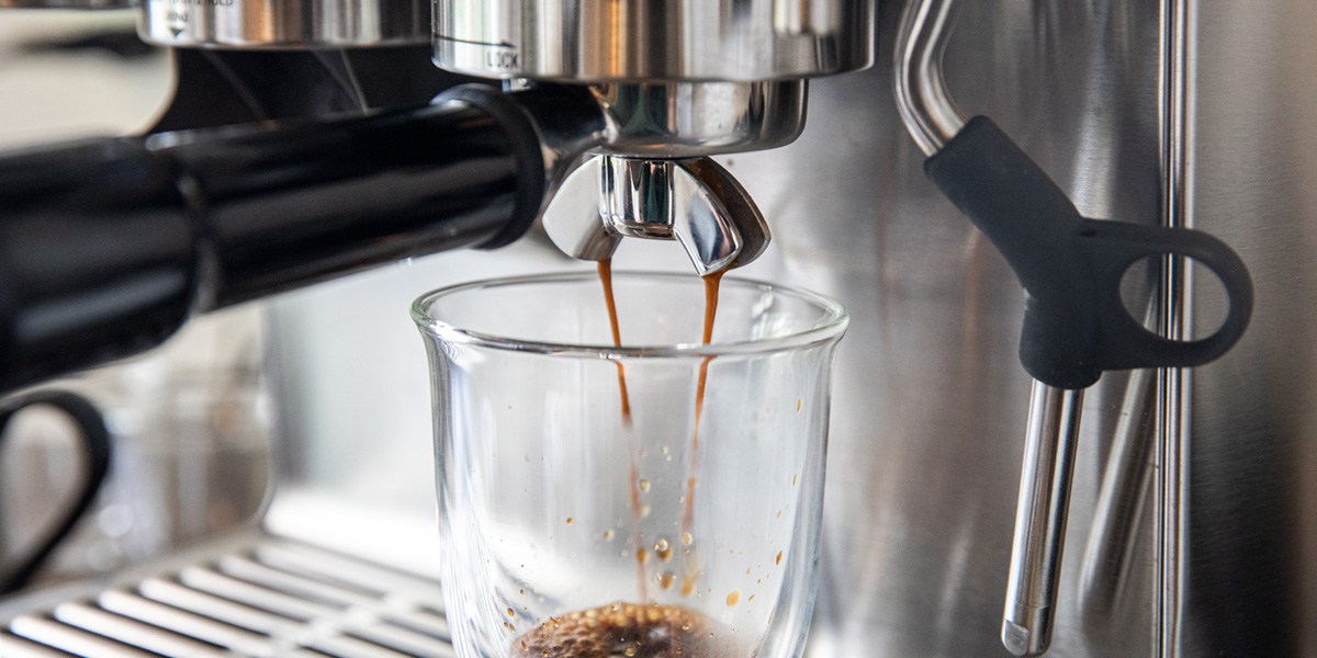 Espresso machine dispersing espresso into cup
