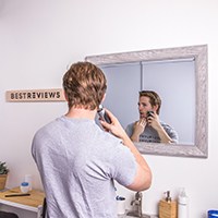 a man shaving in front of a mirror