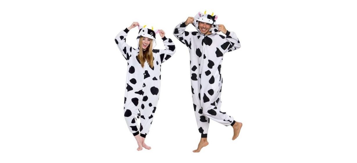2 adults wearing cow onesies