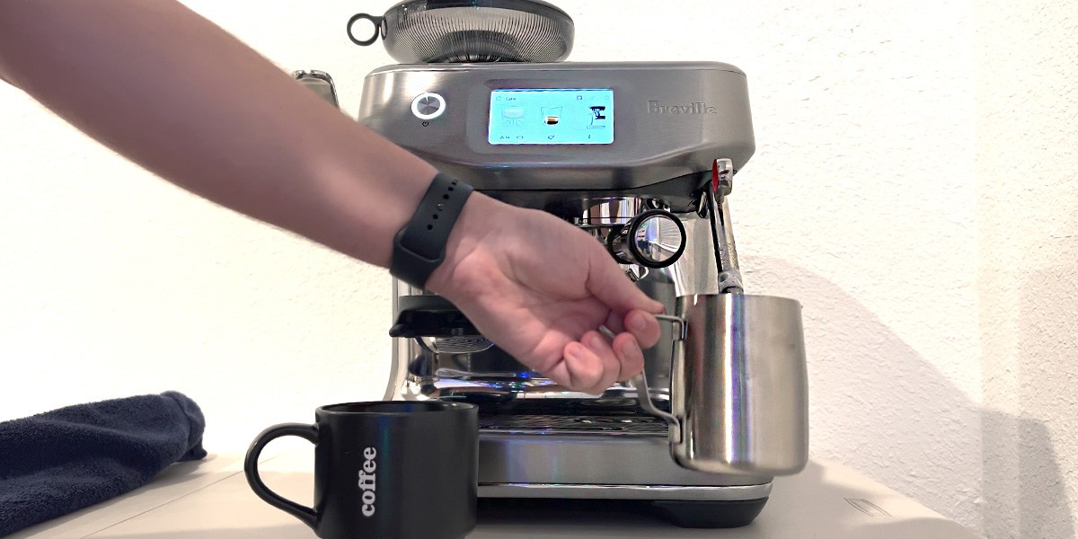 Breville Barista Touch Impress on countertop with hand in front