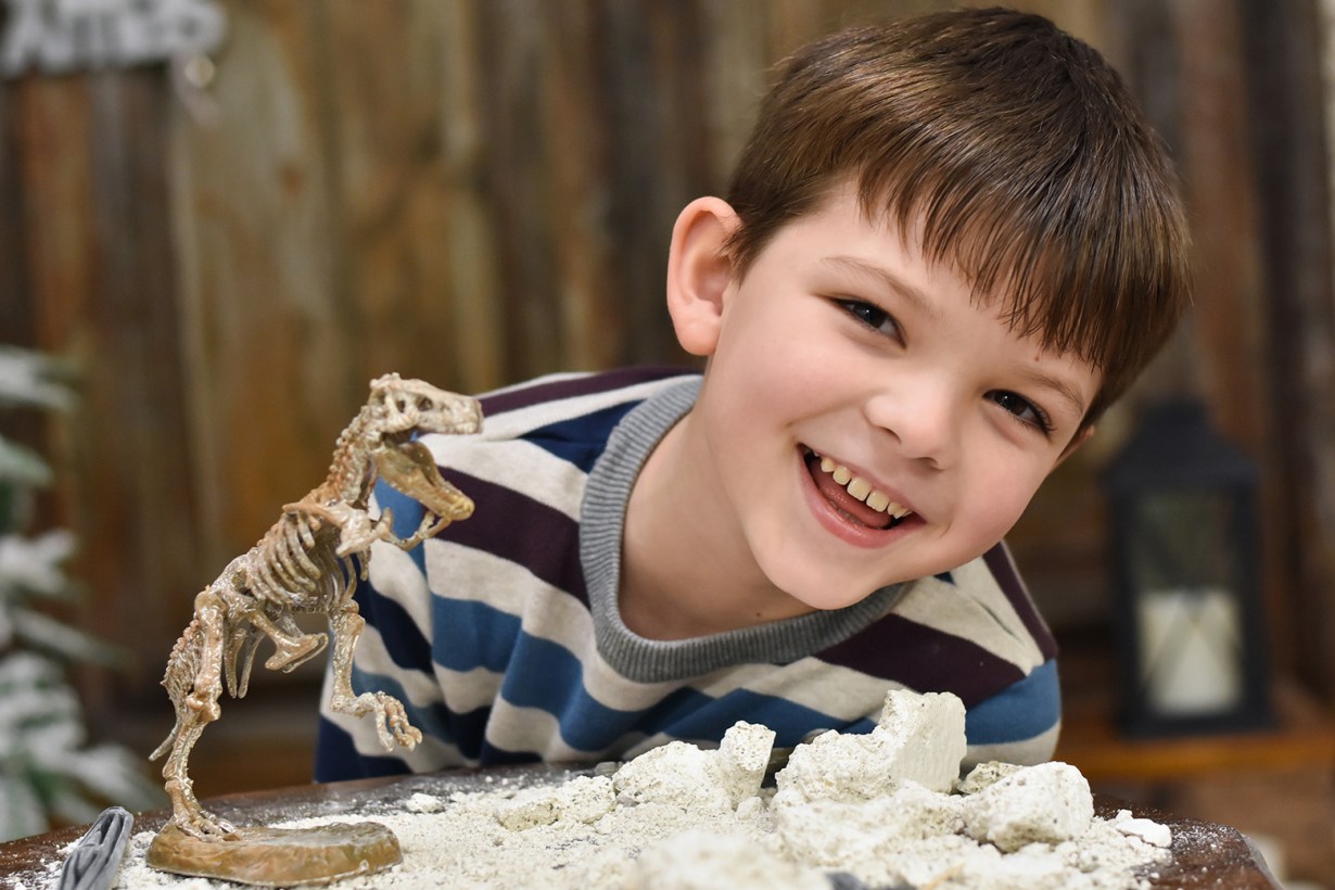 a boy playing with a fossil kit