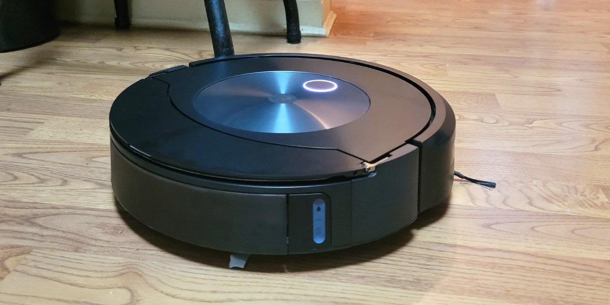 Roomba j7+ cleaning hard flooring in well-lit room